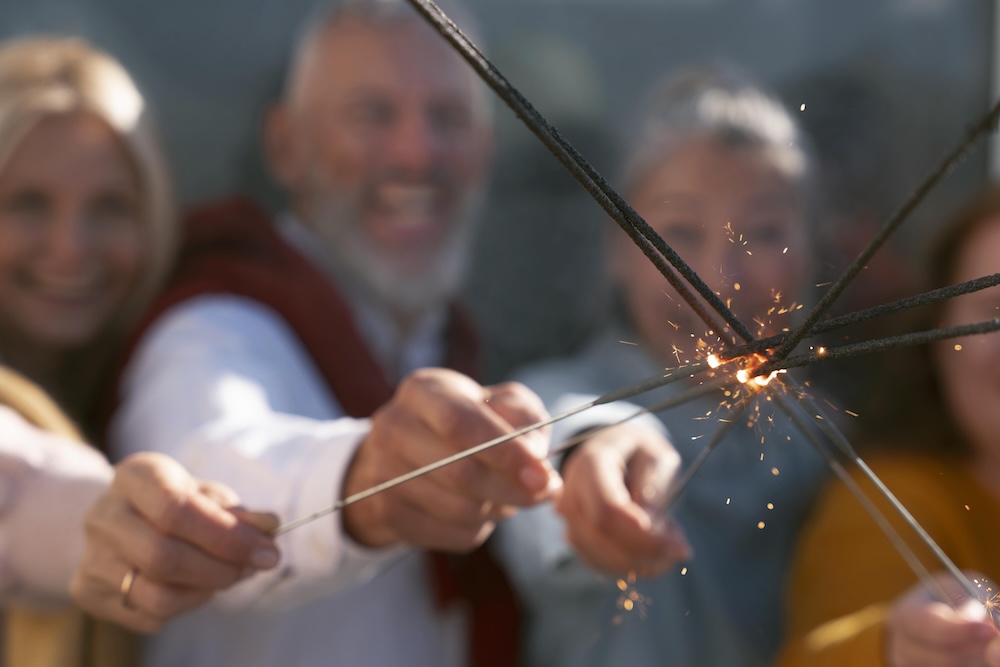 Grupo de personas manipulando bengalas pirotécnicas en celebración de año nuevo con medidas de seguridad