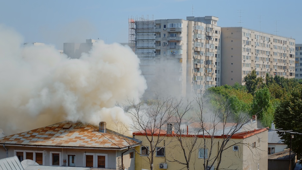 Emergencia incendio en bloque pisos - columna humo visible desde exterior edificio