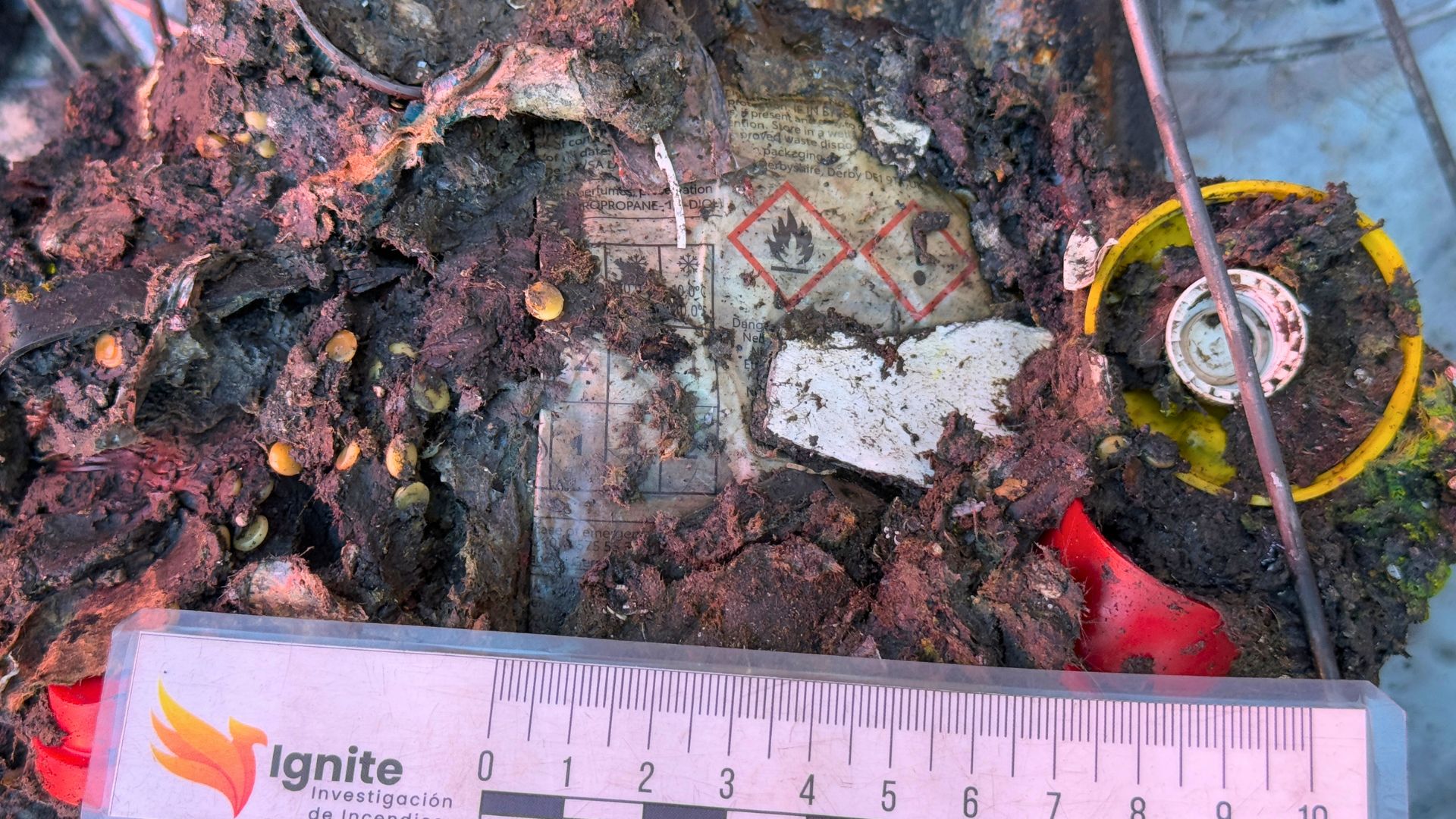 Interior de planta de reciclaje siniestrada durante trabajos de investigación de incendios con maquinaria retirando restos calcinados